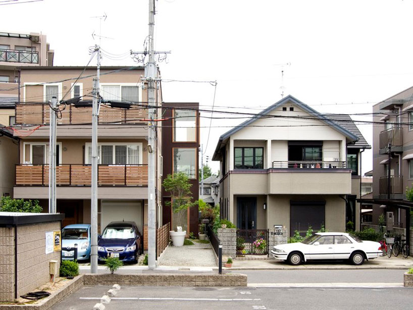 yaneura design sets hagoromo house amid neighboring homes