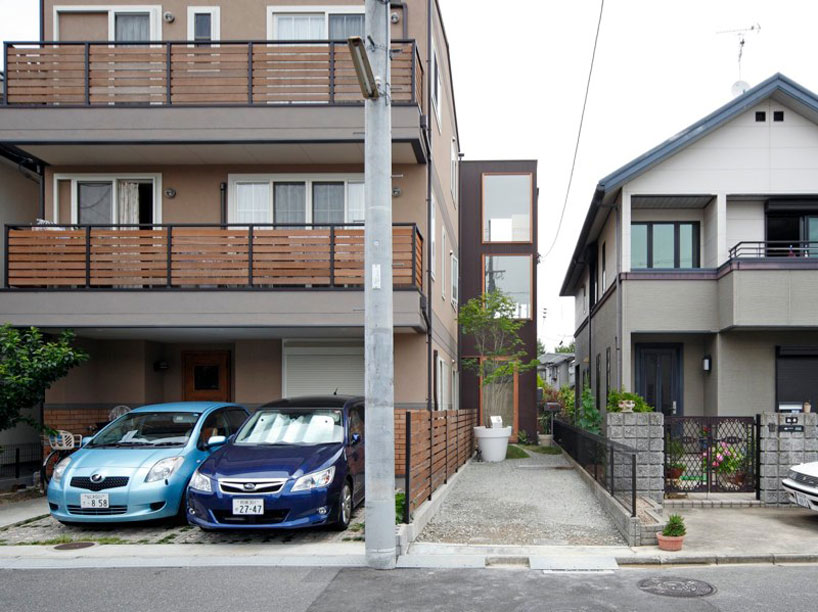 yaneura design sets hagoromo house amid neighboring homes