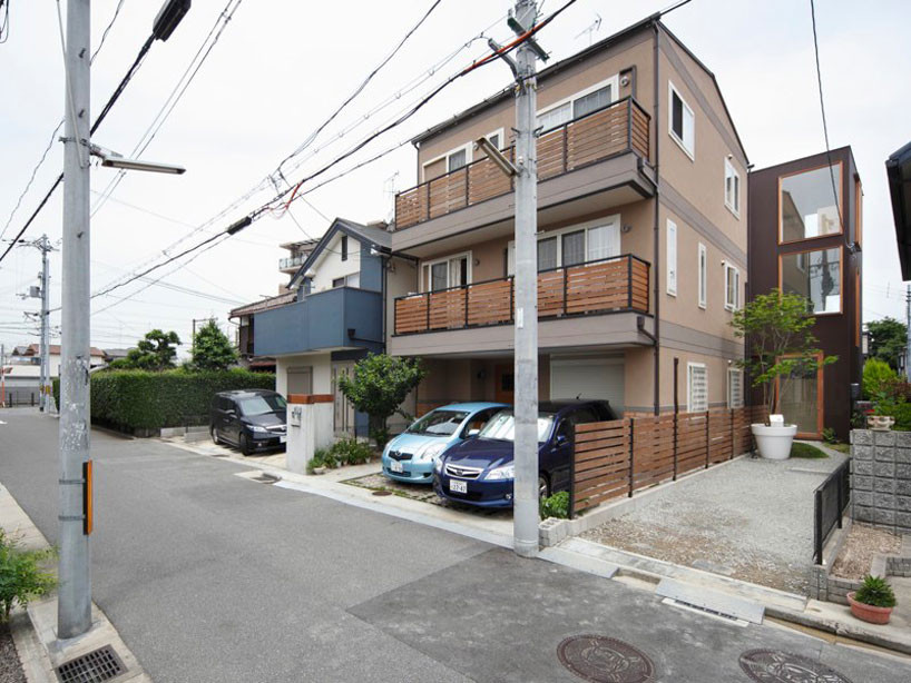 yaneura design sets hagoromo house amid neighboring homes
