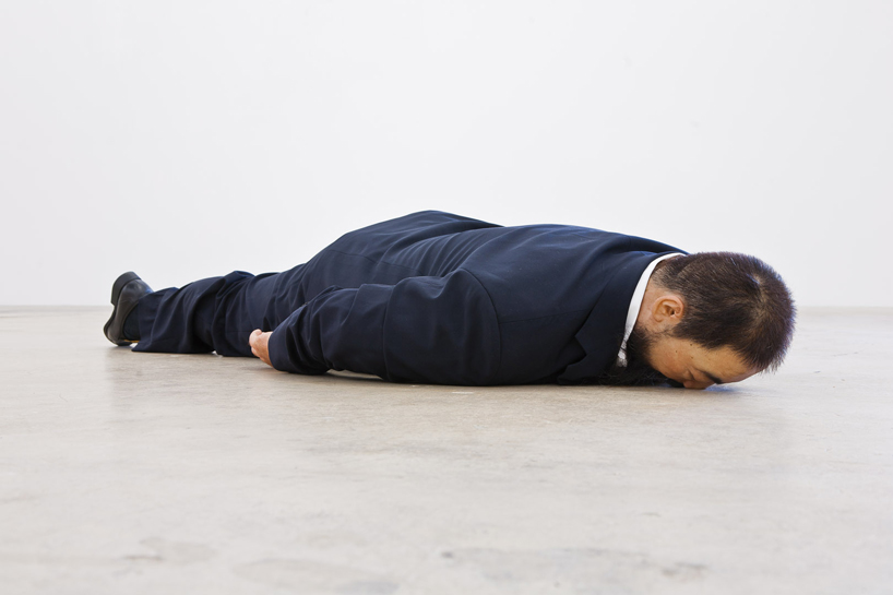 sculpted ai weiwei by he xiangyu lies face down on the ground