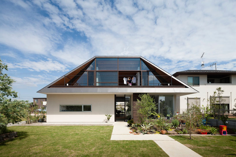 house with a large hipped roof by naoi architecture & design office