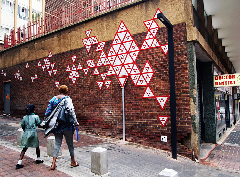 r1 arranges 100 yield signs in a johannesburg alleyway