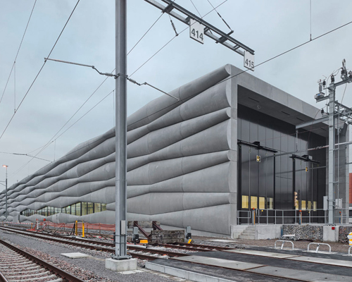 EM2N clad railway service facility with billowing cement facade