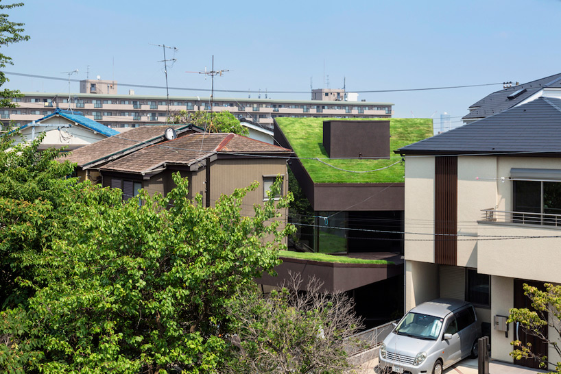 makiko tsukada angles grass cave house between suburban homes