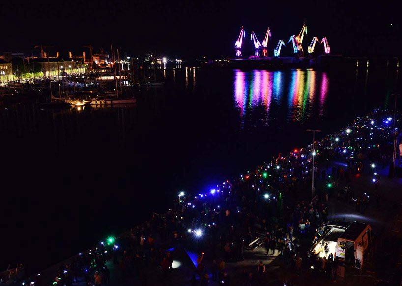 skira's illuminated shipyard cranes look like orgami in the sky