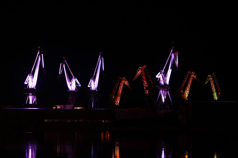 skira's illuminated shipyard cranes look like orgami in the sky