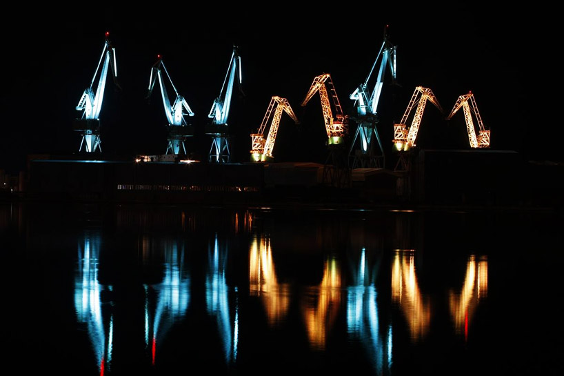 skira's illuminated shipyard cranes look like orgami in the sky