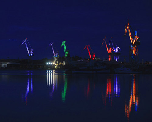 skira's illuminated shipyard cranes look like origami in the sky