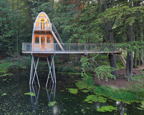 baumraum elevates treehouse solling above pond in germany