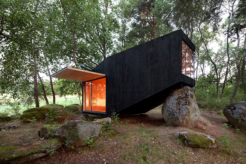 uhlik architekti balances private forest retreat on top of boulder