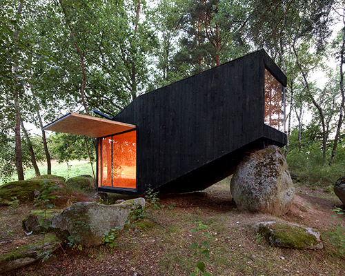 uhlik architekti balances private forest retreat on top of boulder