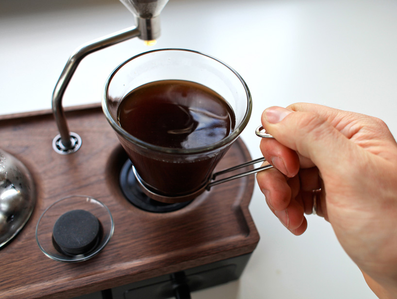 close up view of coffee maker, alarm clock and cup of coffee isolated on  red Stock Photo by LightFieldStudios