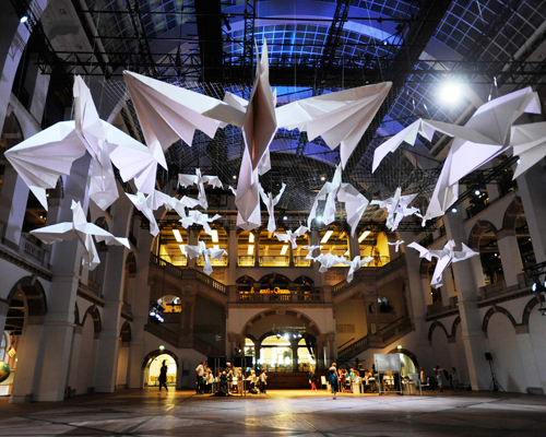 sipho mabona flocks gigantic origami birds in tropenmuseum's great hall