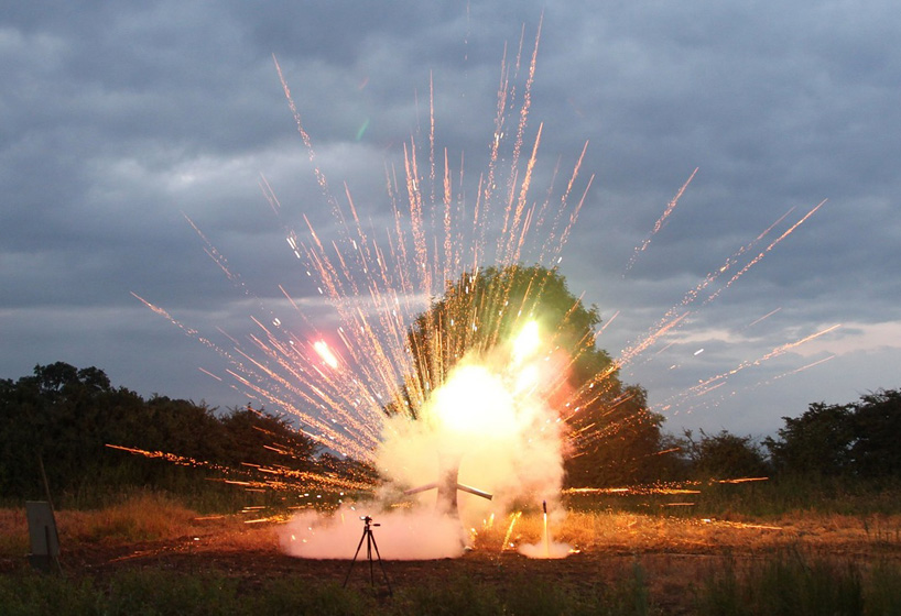 colin furze stands inside a fireworks display with self-built steel suit