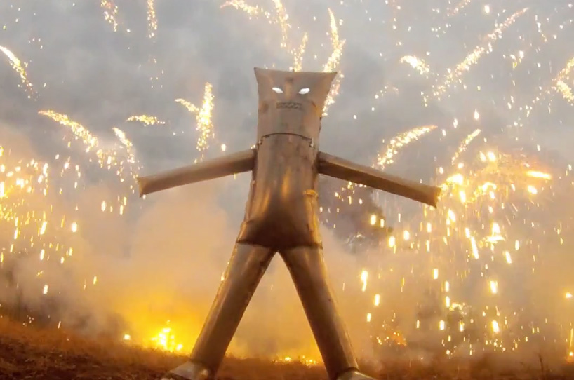 colin furze stands inside a fireworks display with self-built steel suit
