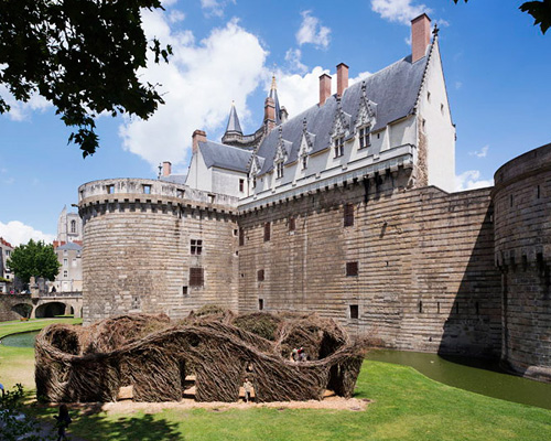 patrick dougherty weaves 'fit for a queen' at castle moat in nantes