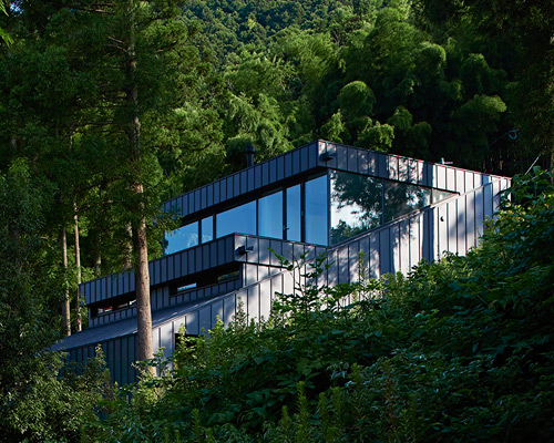 house in raizan forest by rhythmdesign cascades down hillside in japan