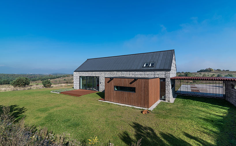 kropka studio projects a house in the landscape of stone and wood