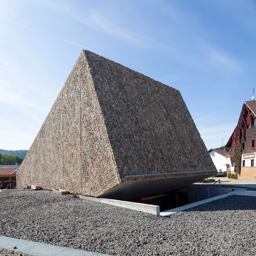 peter haimerl tilts stone-clad concert hall in blaibach, germany