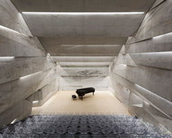 peter haimerl tilts stone-clad concert hall in blaibach, germany