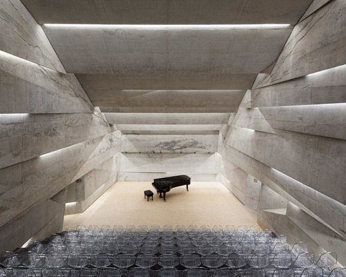 peter haimerl tilts stone-clad concert hall in blaibach, germany