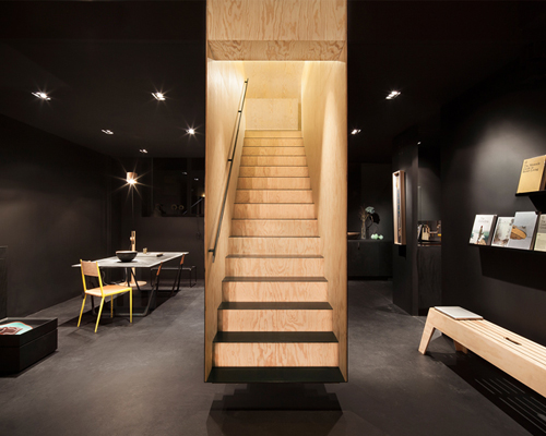 a floating staircase defines interior of bazar noir by hidden fortress