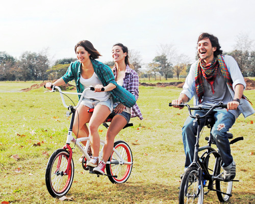 Two people deals riding a bike