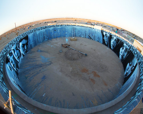 artists paint circular mural inside abandoned water tank in the desert
