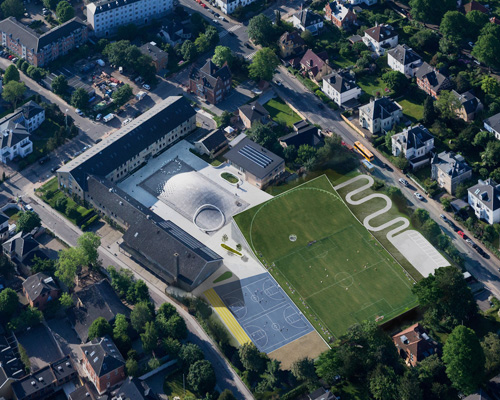 bjarke ingels expands gammel hellerup school beneath a lifted football field