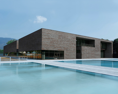 camillo botticini architetto clads entire brescia swimming center with black brick