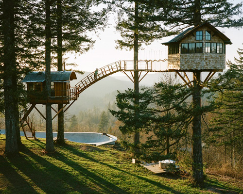 self-built cinder cone treehouse perches above a skate bowl and hot tub