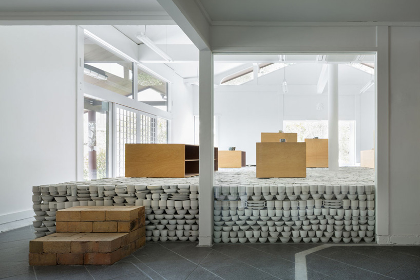 yusuke seki layers unwanted ceramic tableware to form elevated platform in japan