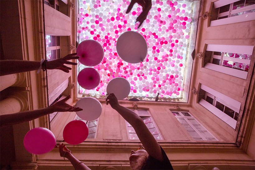 hundreds of hanging balloons turn french courtyard into a hazy pink haven