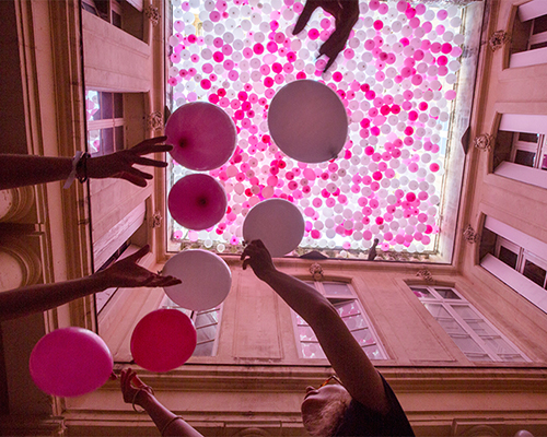 hundreds of hanging balloons turn french courtyard into a hazy pink haven