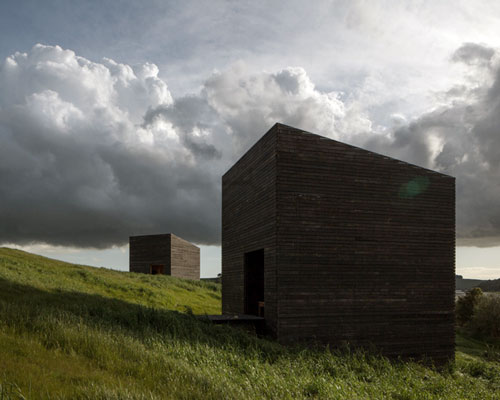 cheshire architects embeds monolithic eyrie cabins into rural new zealand landscape