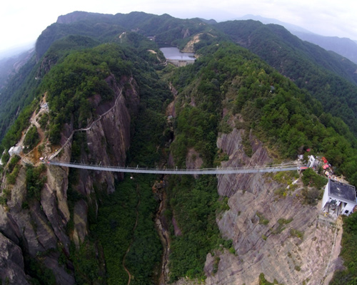 glass suspension bridge spans between two cliffs in china's shiniuzhai park