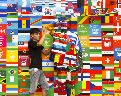 liu bolin camouflages himself against 193 UN flags for the global goals campaign