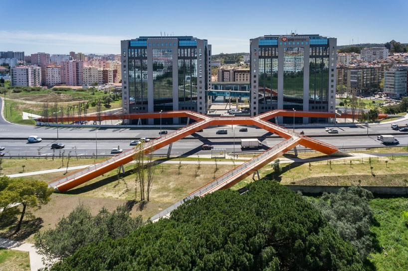 maximina almeida + telmo cruz overlap orange steel bridge above highway in lisbon