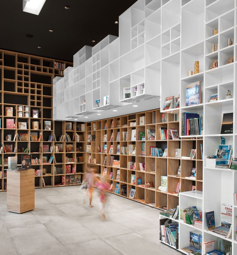 sono architects envelops slovenian bookstore with geometric timber shelving