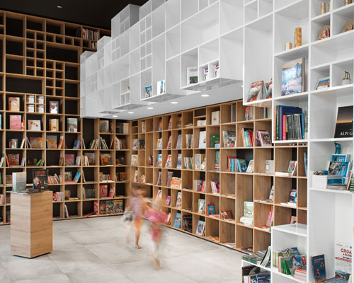sono architects envelops slovenian bookstore with geometric timber shelving