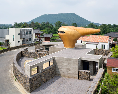 moon hoon installs a golden beak-shaped tower atop his wind house residences