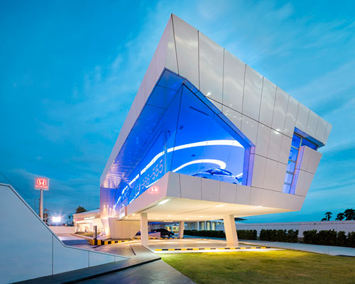 nakornchaisri honda showroom by office AT displays cars within an elevated glass façade