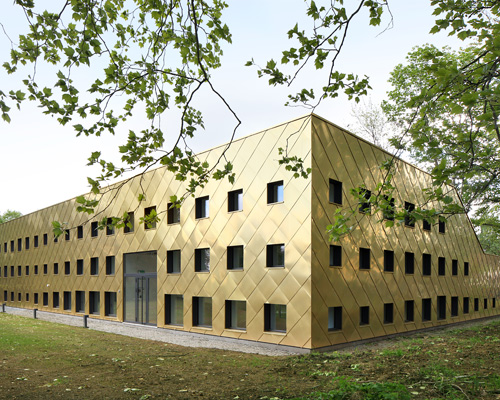 plus office architects clads sustainable library completely with golden panels in belgium