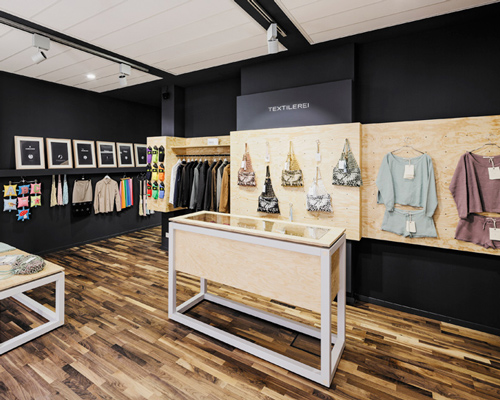 yalla yalla! adds a pine exhibition wall to a showroom for textile startups