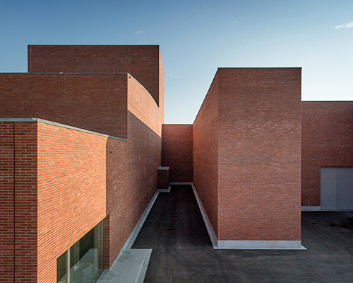 álvaro siza forms public auditorium in catalonia with monolithic red brick volumes
