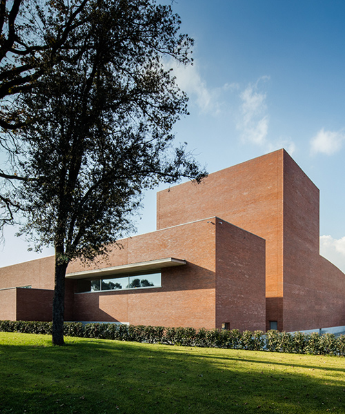álvaro siza forms public auditorium in catalonia with monolithic red brick volumes