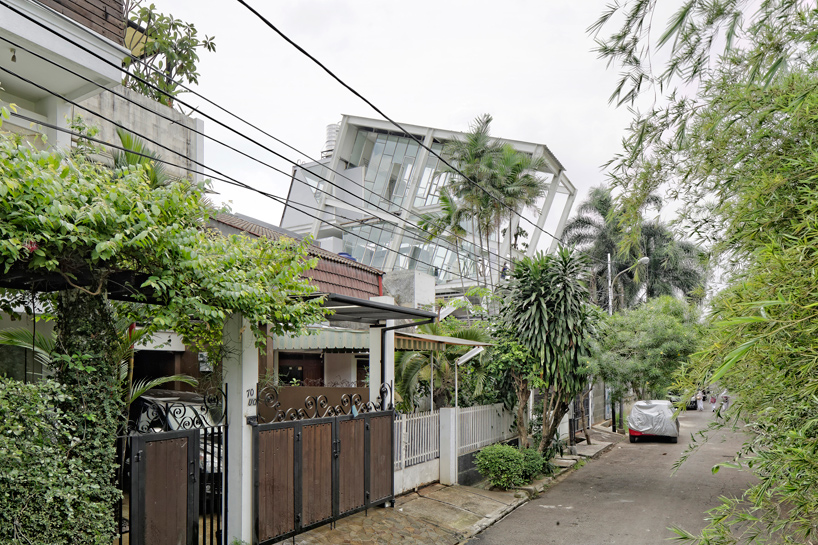 budi pradono encloses glass home  within tilted steel frame 