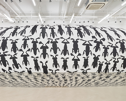 frogs funnel into the floor for regina silveira's amphibia installation