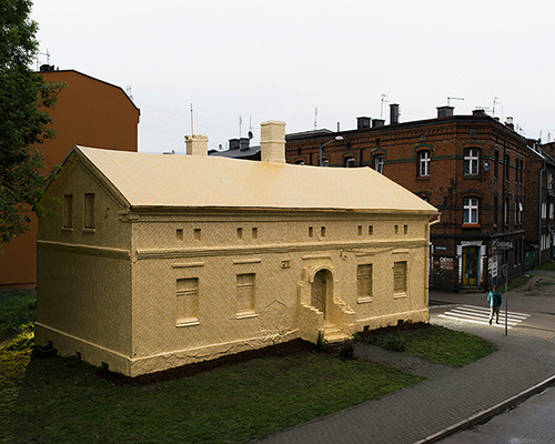 ian strange wraps historical building in poland with 600 sq meters of gold wallpaper