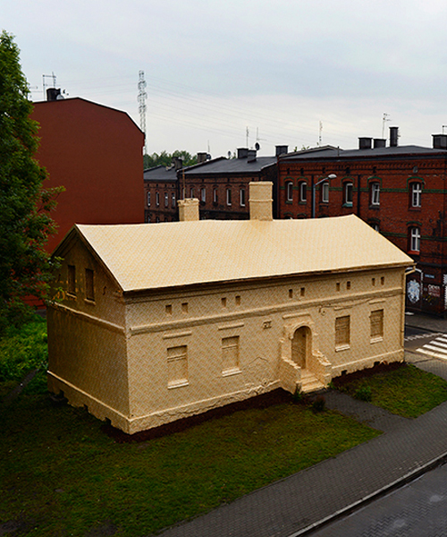 ian strange wraps historical building in poland with 600 sq meters of gold wallpaper